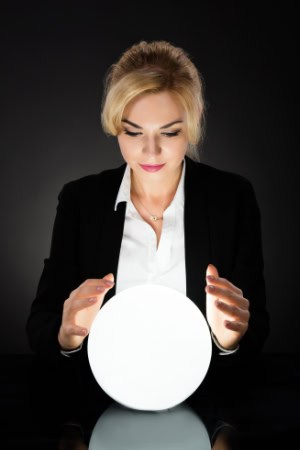 business woman gazing at glowing crystal ball for recruitment predictions.